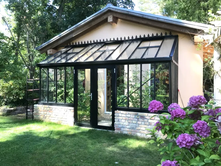 Gewächshaus im Garten mit Blumen, gebaut von HOGATEK von Hof und Garten Wittstock.