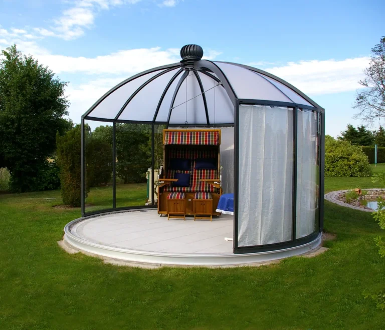 Rundes Glashaus mit Strandkorb im Garten. HOGATEK von Hof und Garten Wittstock.