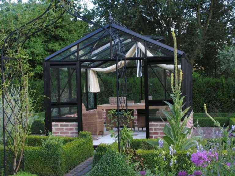 Glasgewächshaus in gepflegtem Garten mit Sitzbereich, HOGATEK von Hof und Garten Wittstock.
